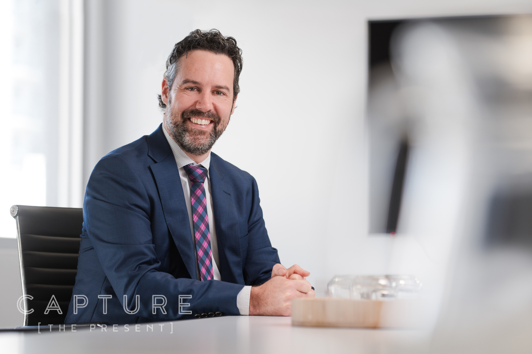 Executive in a suit seated at a desk in a corporate office