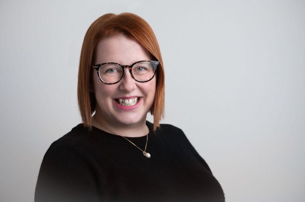 Psynapse clinician with red hair and glasses in a staff headshot