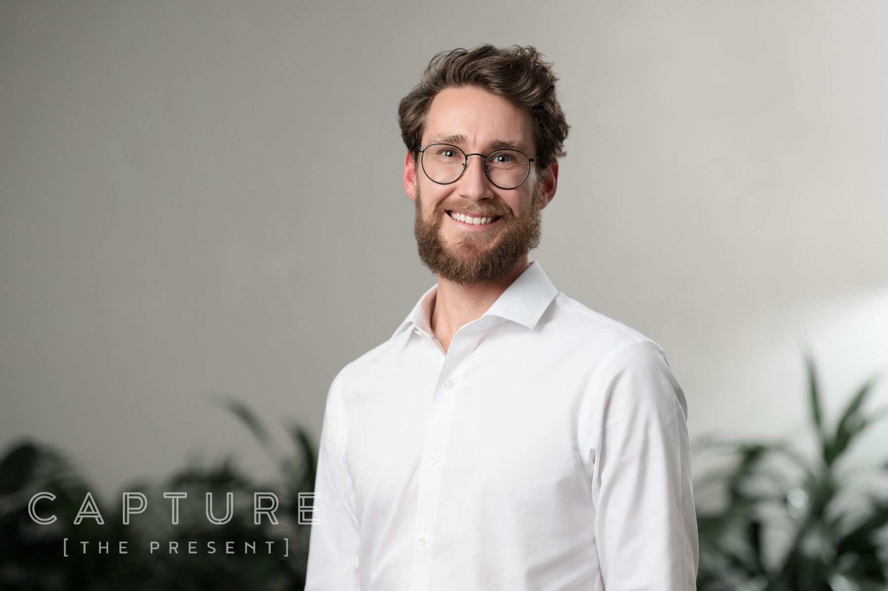 Bearded man in a white shirt photographed in a bright office