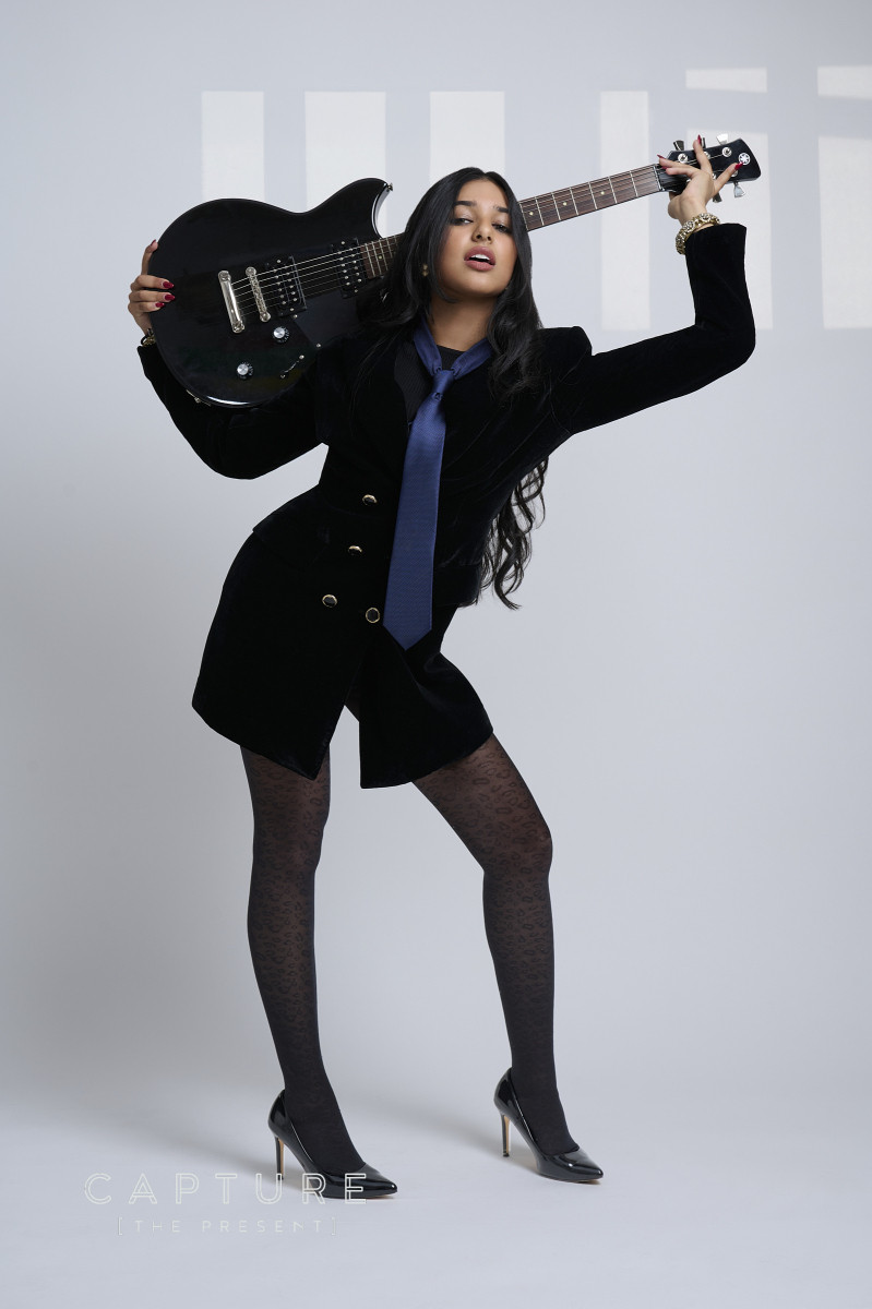 Adelaide singer Twisha posing with a black electric guitar in a studio portrait at Cog Creative Space
