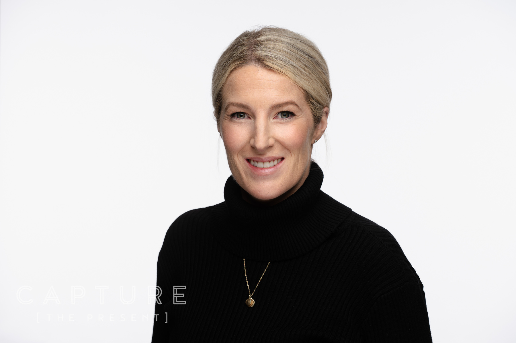 Woman with short hair in a black top on a clean white backdrop