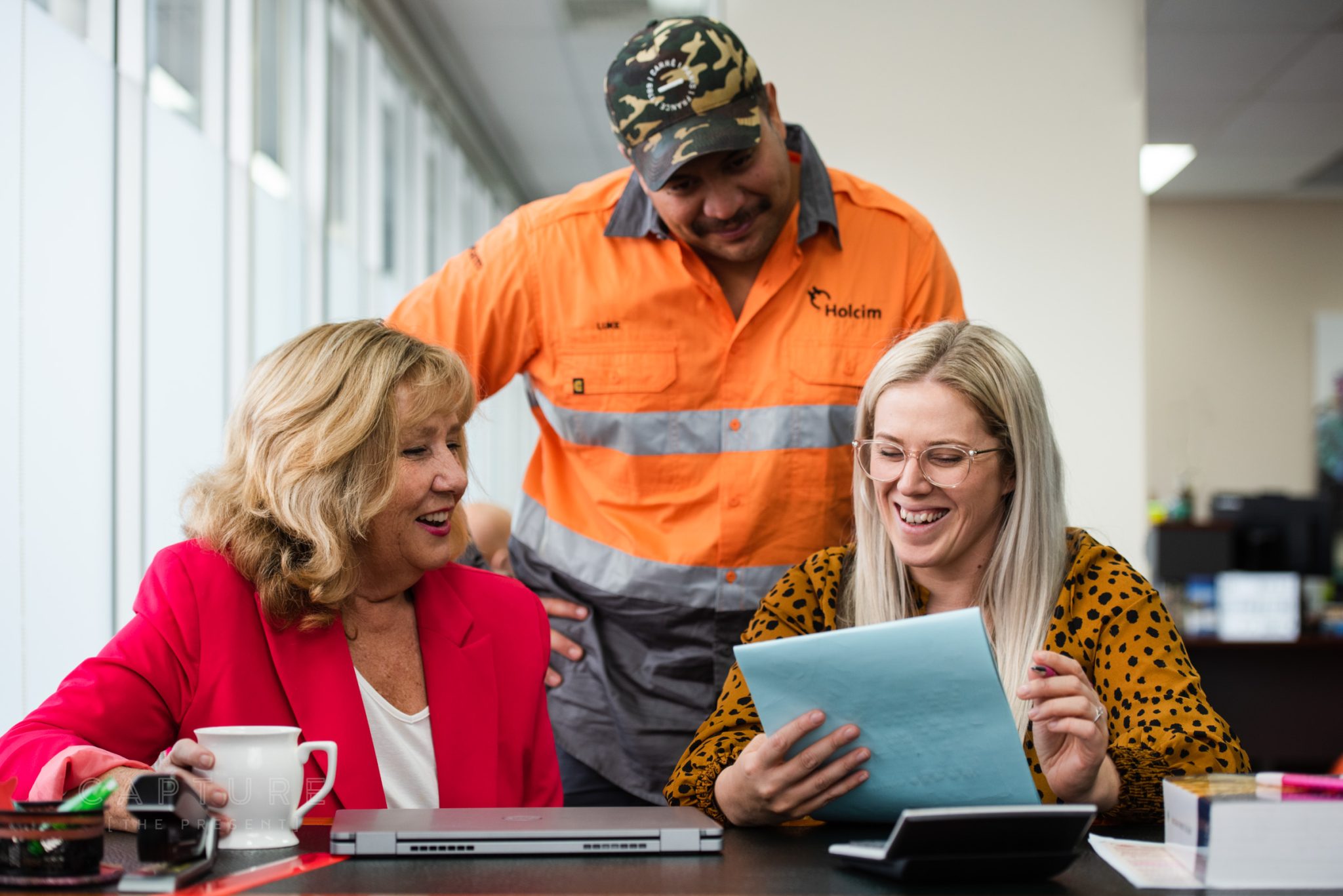 Practice manager Tamika with clients including a tradesman at DMC Tax in Mawson Lakes