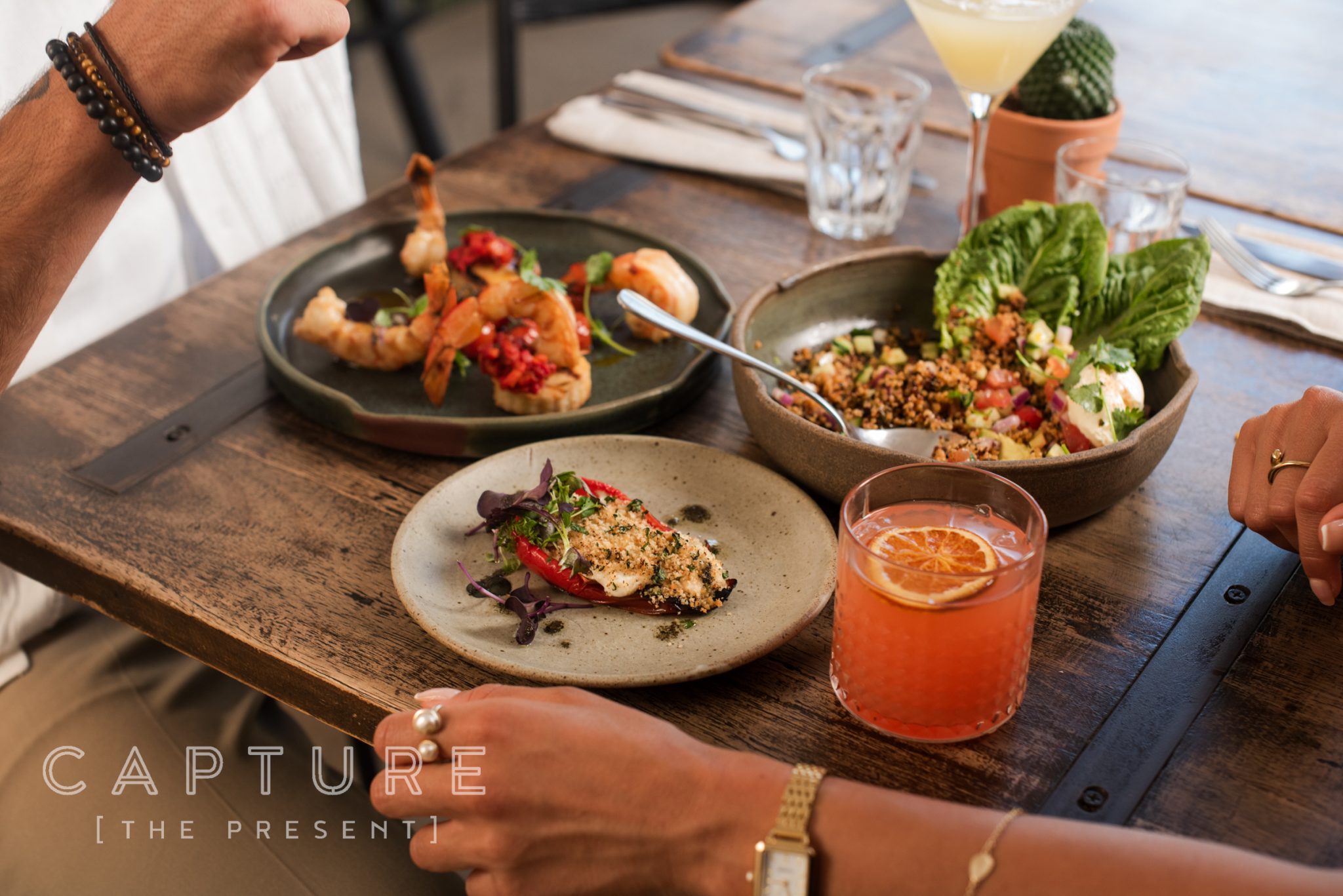 Plated dishes and a cocktail on a wooden board at a Barossa Valley restaurant