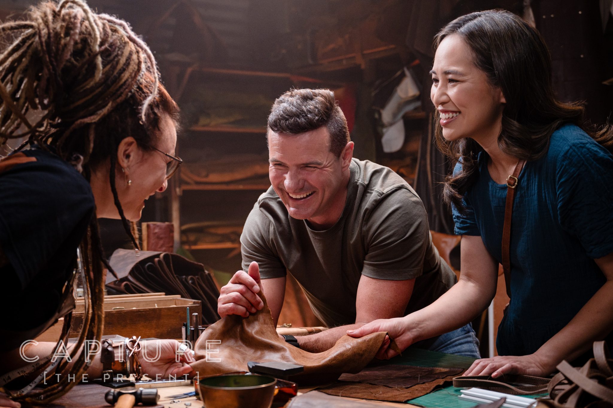 Three people working leather together at a bench in a Barossa Valley workshop