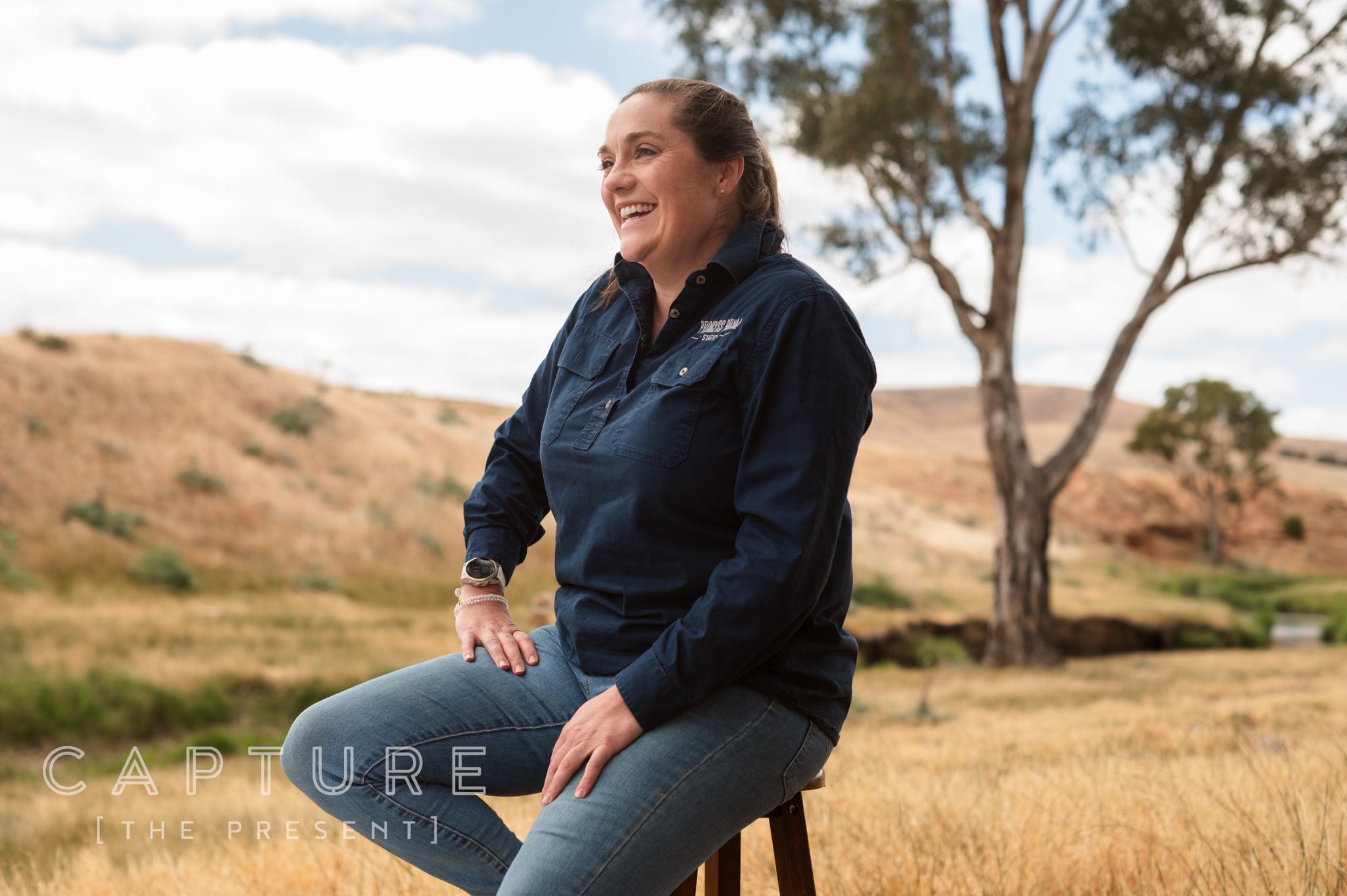 Station worker seated under a gum tree in dry grass, Mid North South Australia