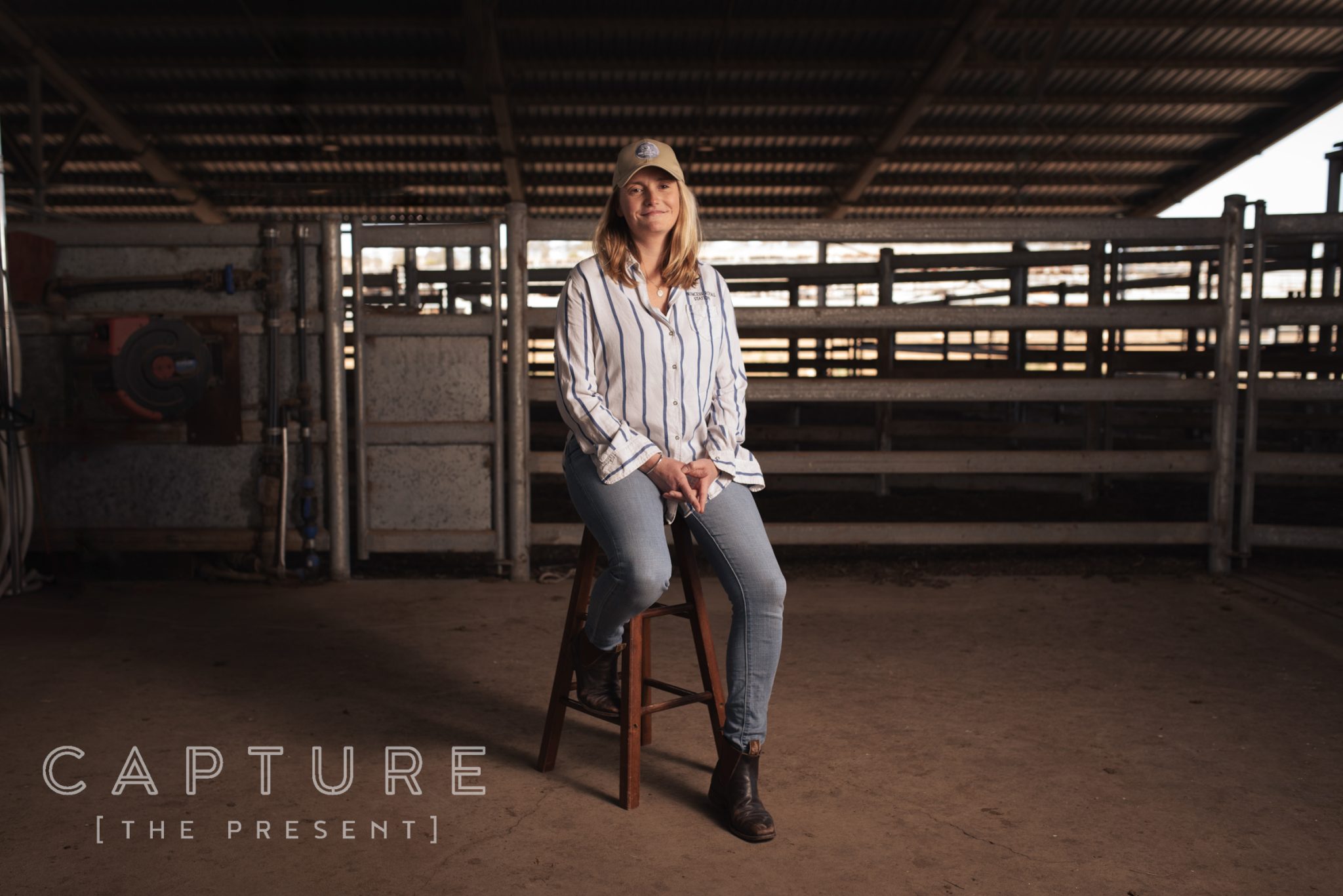Station worker sitting on a stool in the cattle yards at Princess Royal Station
